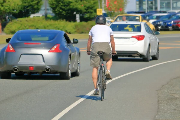 Rowerzysta Ruchliwym Ruchu Nosi Kask Bezpieczeństwa Ale Ignoruje Inne Istotne — Zdjęcie stockowe