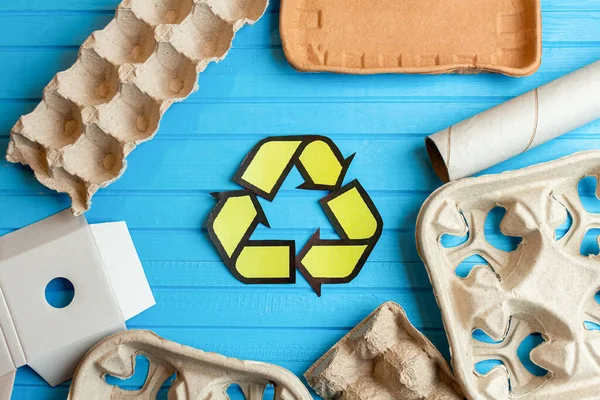 Paper, cardboard, cartoon used waste with a recycling sign on blue background