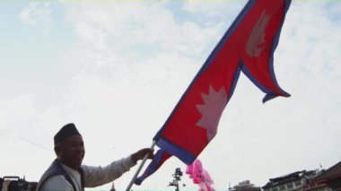 Kuşlar gökyüzünde uçuyor iken Nepal - Septemder 2018:A onların geleneksel kostüm giyen Nepalis adam patriotically onların bayrak sallıyor.