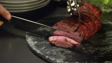 Orta az pişmiş biftek ince parçalar halinde bir restoran Noel akşam yemeği için dilimleme.