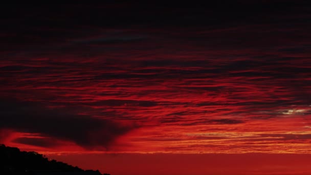 Ciel rouge surplombant la silhouette d'un flanc de montagne — Video