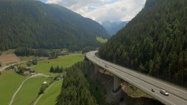 Vista panorámica de una autopista al lado de una montaña con coches conduciendo a través de la curva — Vídeo de stock