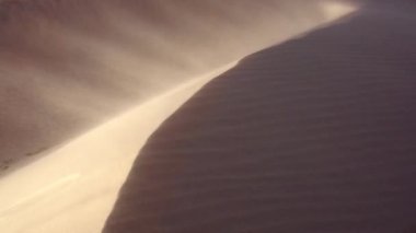 Güney Afrika üzerinde kum tepeleri üzerinde kum esen rüzgar görüntüsünü kapatmak