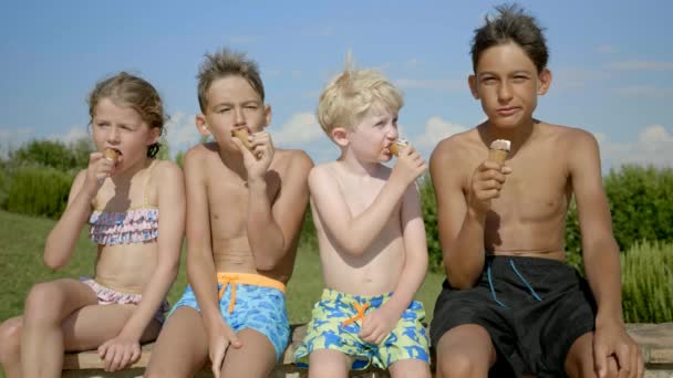 Ein Mädchen Und Drei Jungen Essen Fröhlich Eistüten Während Sie — Stockvideo