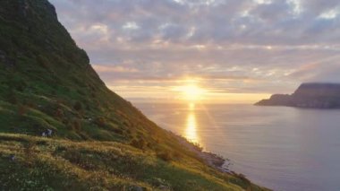 Ufukta Güneş ayarı bir dağın ve okyanusun bir belirti ile ısmarlayarak.