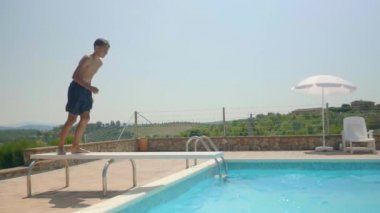 Genç bir adam bir tatil ev Toskana bir konaklama sırasında havuza atlama bir video