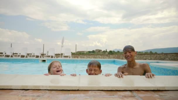 三个顽皮的孩子在慢镜头笑的时候从游泳池里走了出来 — 图库视频影像