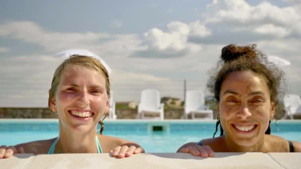 Dos Chicas Relajándose Piscina Mientras Sonríen Cámara Una Mañana Soleada — Vídeos de Stock