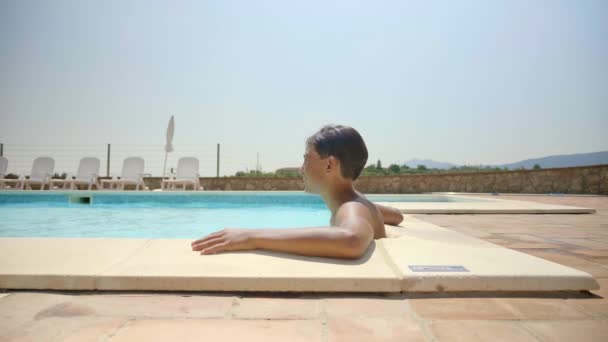 Menino Relaxando Piscina Com Vista Para Céu Fundo — Vídeo de Stock