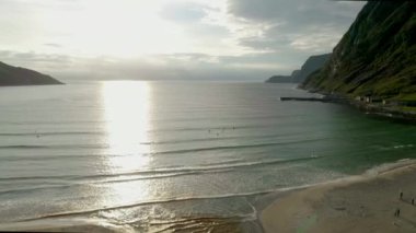 Kuş bakışı görünüm gün batımının tadını çıkarırken dalgalar için bekleyen sörfçü.