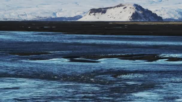 Tiro de la playa de arena negra con montañas cubiertas de nieve en el fondo — Vídeos de Stock