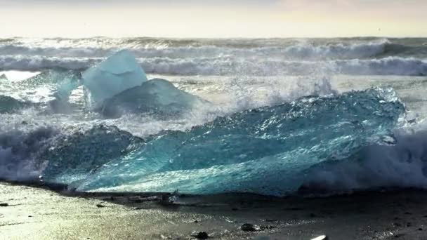 海浪不断地冲击着钻石海滩上的一大块冰山 — 图库视频影像