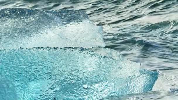 Μικρά κύματα συντρίβεται μέσα από ένα μικρό παγόβουνο — Αρχείο Βίντεο