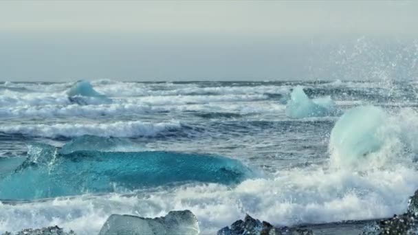 Vågorna kraschar genom isberg i Diamond Beach. — Stockvideo