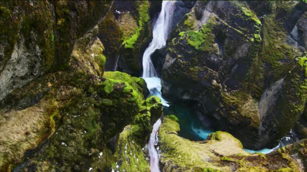 カスケード接続された岩と苔 アイスランドを通って動く流れの空中ショット — ストック動画
