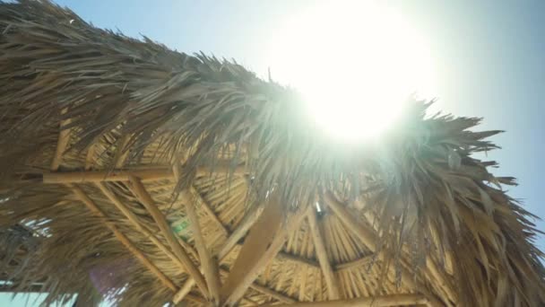 有名なキューバのビーチのワラ小屋でのショットに焦点を当てた フレームに太陽フレア — ストック動画