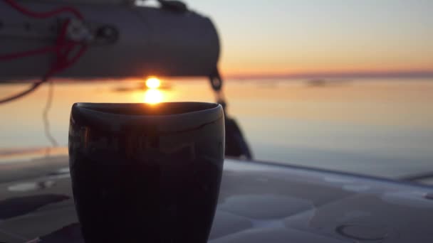 背景の夕日で ヨットの上で撮影したコーヒーのカップに実用的な浅い — ストック動画