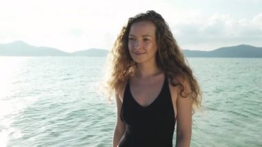 Beach'te yürürken modelinin kıvırcık saç Rüzgar esiyor
