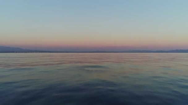 日没時にスペインの穏やかな海の上のショットを滑空します — ストック動画