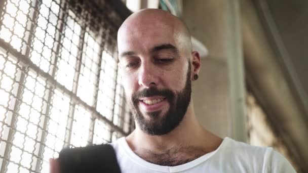 Homem careca com barba sorrindo enquanto mensagens de texto — Vídeo de Stock