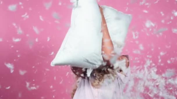 Пір'яна подушка кинута дівчиною — стокове відео