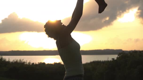 Mittlere Aufnahme einer liebenden Mutter und eines verspielten Sohnes im Sonnenuntergang — Stockvideo