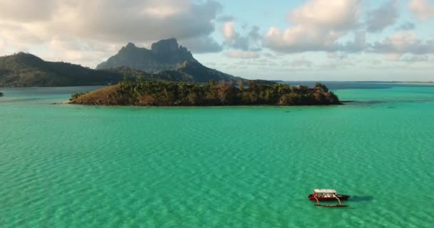 在清澈的水晶湖中，一艘船在岛上巡航的平稳镜头 — 图库视频影像