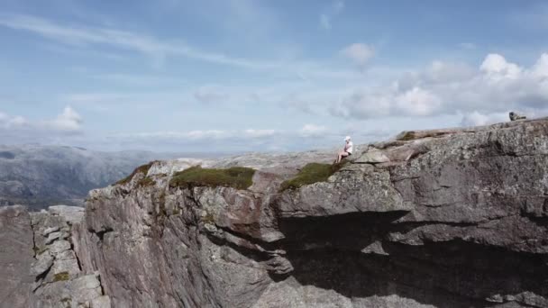 Luchtfoto van een vrouw zittend bij de rand van een klif bij Pulpit Rock — Stockvideo