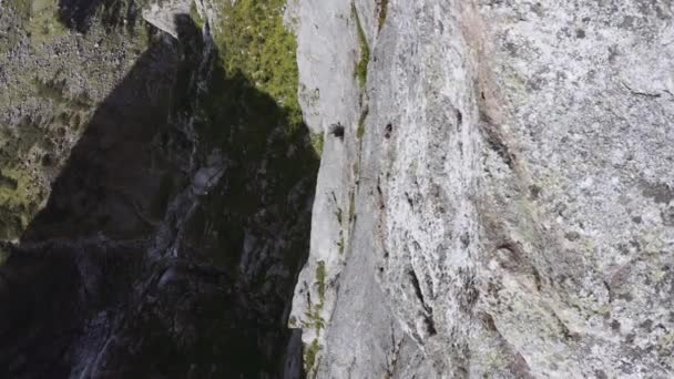 Szoros lövés egy drónról, amint átrepül egy sziklán, felfedve ezzel Scree-t. — Stock videók