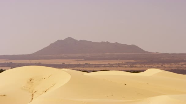 砂の砂丘と岩の形成の広いショット、それから澄んだ空を明らかにするための傾き — ストック動画