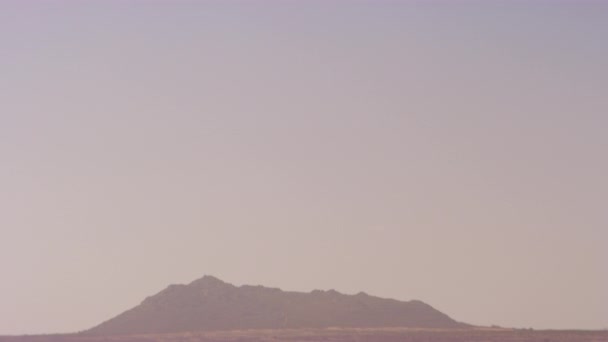 Inclinarse hacia abajo para revelar las dunas de arena y una silueta de una montaña del desierto — Vídeo de stock