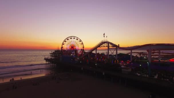 Zoom in, Fly Over Shot van de Santa Monica Ferris Wheel and Beach op een zonsondergang — Stockvideo