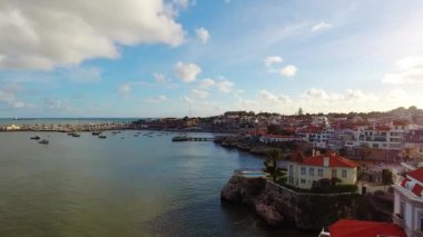 Cascais 'deki kıyı şeridinin, uçurum boyunca uzanan lüks evleri ile hava görüntüsü.