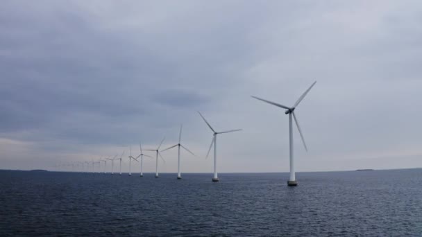 Molinos de viento alineados y rodeados de aguas del océano azul — Vídeo de stock