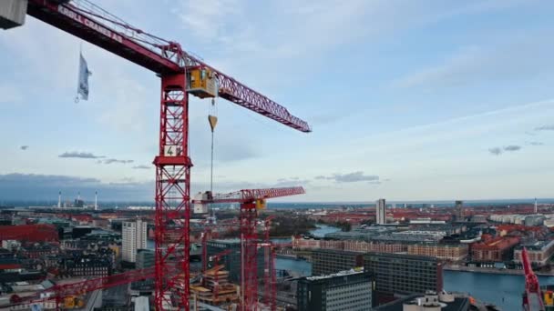 Tiro aéreo de grúas de construcción y calles ocupadas de la ciudad en Dinamarca — Vídeos de Stock