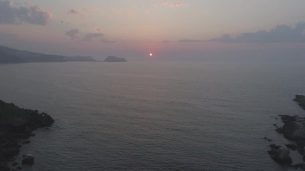 Drone sobre casal assistindo pôr do sol sobre o mar — Vídeo de Stock