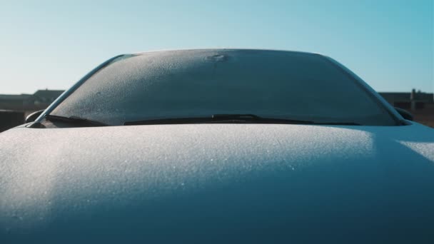 Ледяное лобовое стекло и автомобильная шапочка морозным утром — стоковое видео