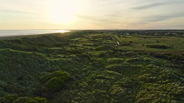 Pobřeží mezi mořskými vodami a zelenými zeměmi v Dánsku pod jasnou oblohou — Stock video
