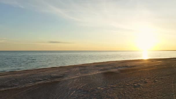 Schöner Sonnenaufgangshimmel und lange Sandstrecken am Strand und ruhige Ozeangewässer — Stockvideo