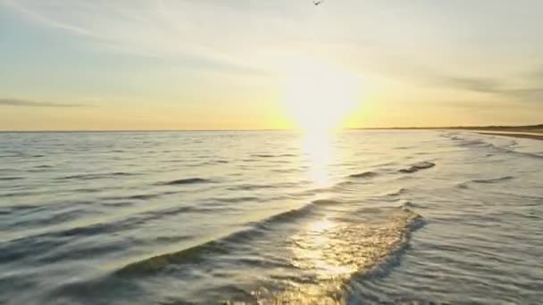 La salida del sol y su reflexión sobre las aguas onduladas de la playa en Dinamarca — Vídeos de Stock