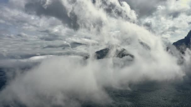 Berg Omgivet av Blå oceanens vatten och vit dimma — Stockvideo