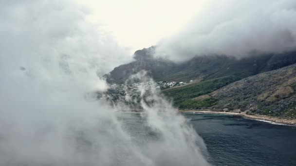 Drone shot van de bergen en de zee bedekt door mist — Stockvideo