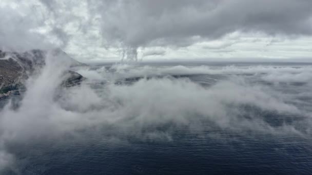 Slow Drone Shot of Deep Blue Seas and Mountain Behind Fog. — Vídeos de Stock