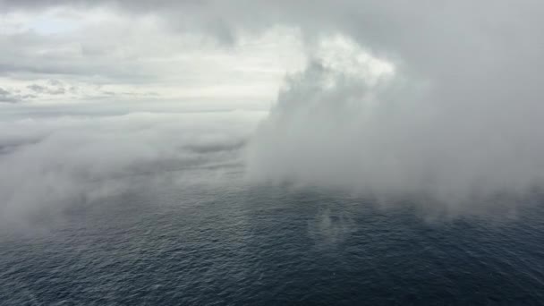 Aguas azules del océano cubiertas de niebla en primer plano y cielo despejado en segundo plano — Vídeos de Stock