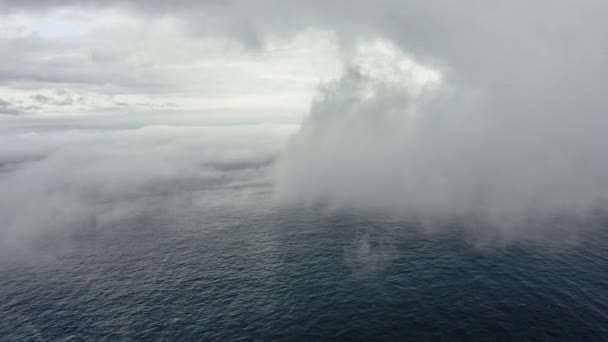 Blauwe oceaanwateren bedekt door mist op de voorgrond en heldere lucht op de achtergrond — Stockvideo