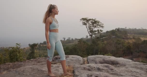 Mujer caminando descalza sobre las rocas en la cima de la montaña — Vídeos de Stock