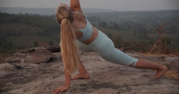 Pretty Fit Mujer en Triángulo Yoga Pose y una vista serena desde la cima de las montañas — Vídeos de Stock