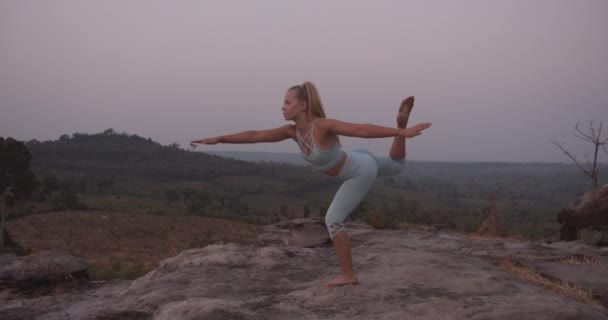 Boční pohled na ženské modelky paže roztažené dělá jógu v horách — Stock video