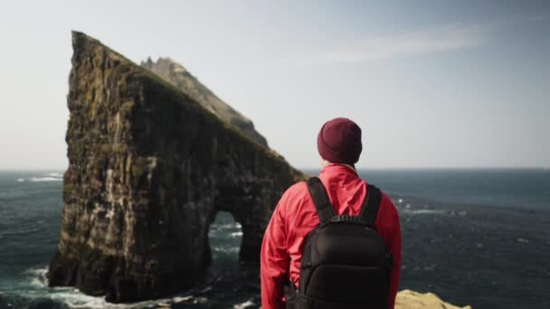 Duży Drangarnir Rock na Wyspie Owczej, Europa i mężczyzna Backpacker — Wideo stockowe