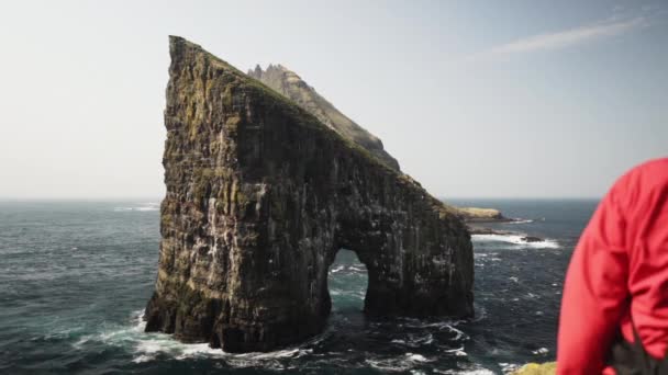 Roccia di Drangarnir e uccelli che volano intorno ad esso nel mezzo dell'acqua blu profonda dell'oceano — Video Stock